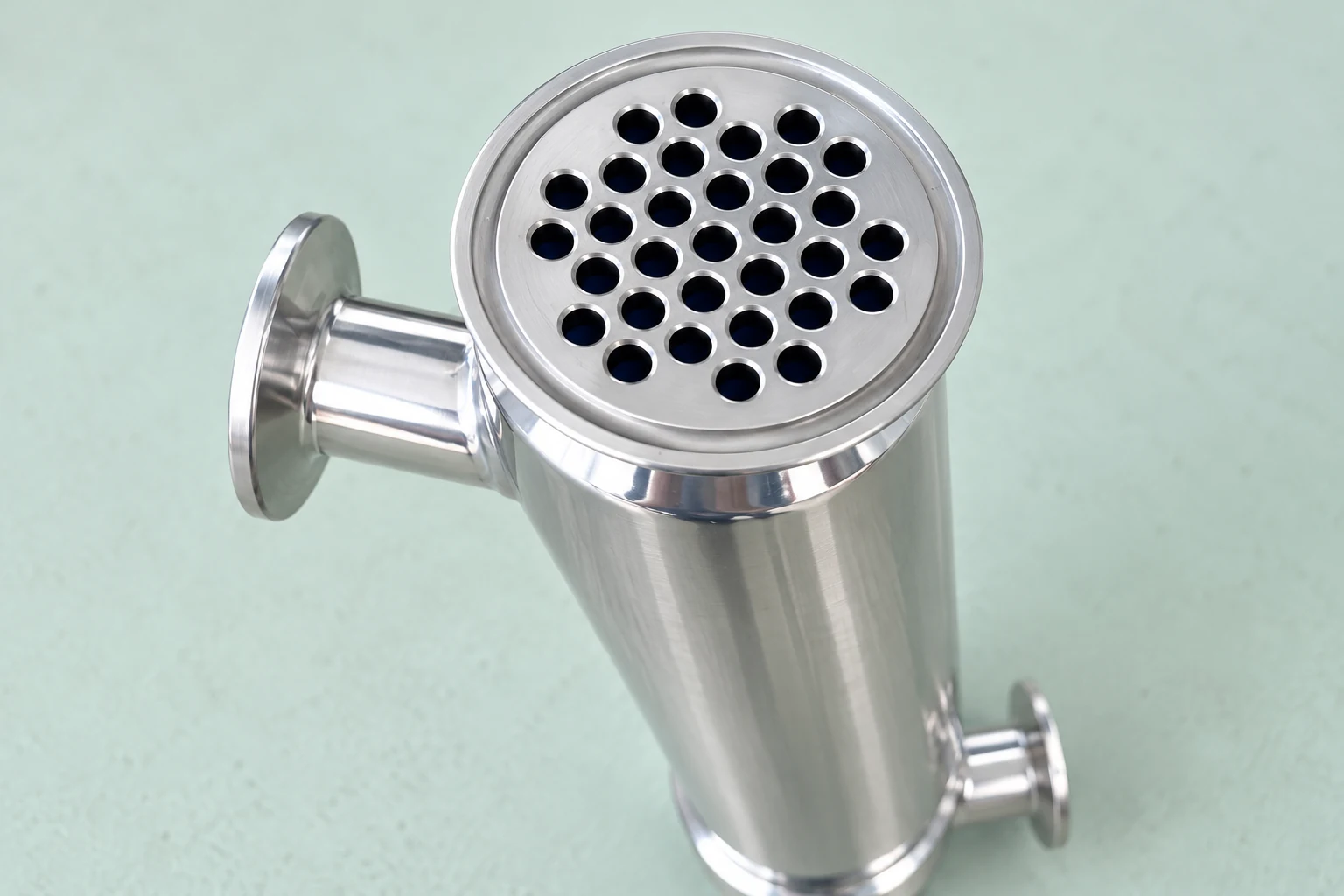 Open sanitary exchanger tube face above a mint inspection bench